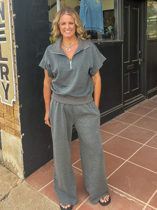 Charcoal color sweatpants with drawstring and wide leg shown with matching top on blonde woman