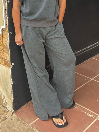 Charcoal color sweatpants with wide leg shown on woman from waist down